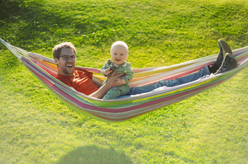portrait of attractive nerd  man  with glasses in the park  with green lawn have a nice sunset with...