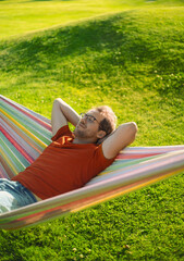 portrait of attractive nerd   man with glasses in the park with green lawn have a nice sunset in ...