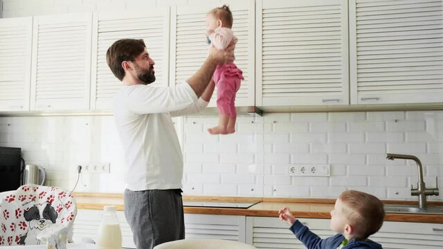 A happy father playing with his children while having breakfast at home