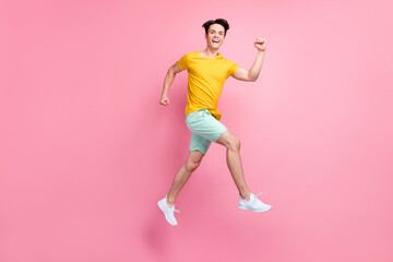 Fototapeta na wymiar Full size profile side photo of young guy happy positive smile jump up go walk run isolated over pink color background