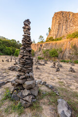 Ein von Touristen aufgehäufter Steinhaufen vor einem Vulkankegel in Ungarn