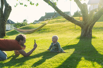 portrait of attractive nerd  man  with glasses in the park  with green lawn have a nice sunset with...