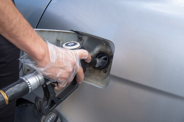 a man equipped with a glove, refueling a diesel tank