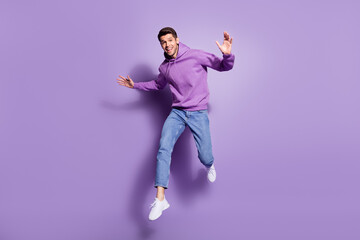 Full length body size photo man jumping up cheerful overjoyed isolated pastel purple color...