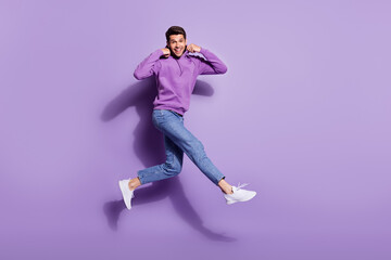 Full length body size photo man jumping up wearing hoody isolated pastel purple color background