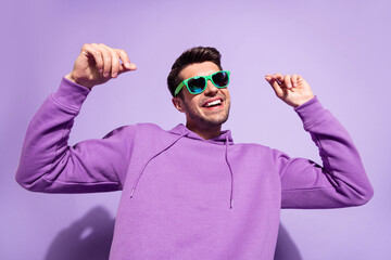 Photo portrait man smiling in sunglass dancing in nightclub isolated pastel purple color background