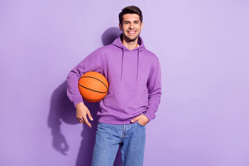 Photo portrait man smiling happy keeping ball in hoody isolated pastel violet color background