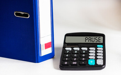 Calculator with word PAUSE on display isolated on white background with blue folder for documents