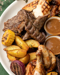 Grilled assorted meat and vegetables. Close-up shot of platter with tasty lunch. Vertical format. Soft focus. Top view.