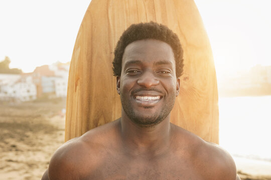 African american surfer man smiling on camera on the beach