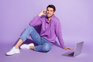 Portrait of attractive cheerful trendy guy agent broker sitting using laptop calling client isolated over purple violet color background