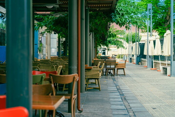 Chairs and tables in an outdoor cafe on a narrow street in Limassol, Cyprus. Nobody.