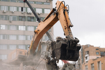 A construction bulldozer demolishes an old house on a clear day.
New construction site.