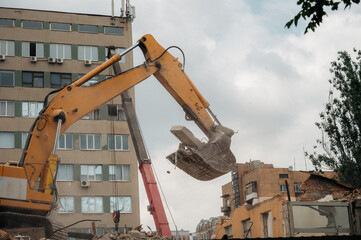 A construction bulldozer demolishes an old house on a clear day.
New construction site.
