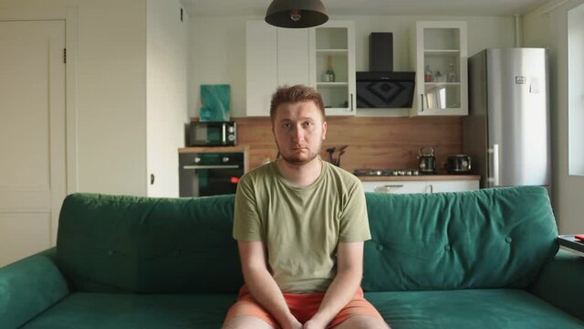 Man sitting couch home. Holds text insertion dream expectation luck sadness. Stress pressure pressing problems. Go in for sports start motivating lazy work. Snaps fingers gets rid annoying thoughts
