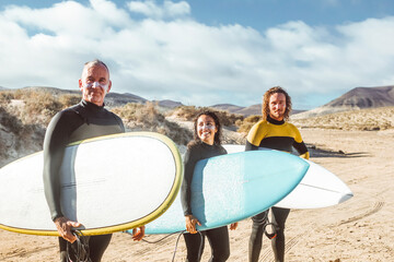 Three friends going to surf in the sea