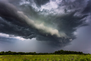 Fototapeta na wymiar Extreme thunderstorm shelf cloud moving over fields, climate change concept