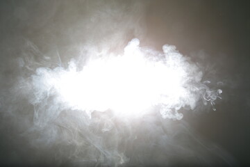 Artificial magic light illuminates smoke on dark background