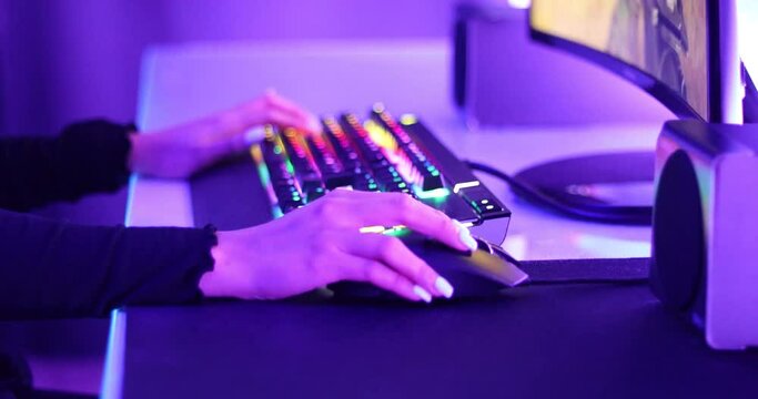 Close up of the hand of a gamer girl, moving the mouse while playing a pc game