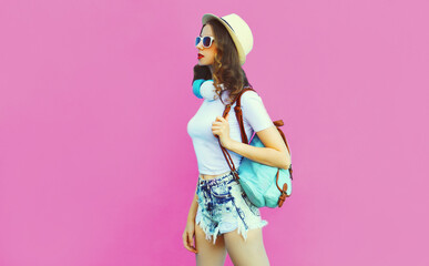 Summer colorful portrait of stylish modern young woman wearing a straw hat, backpack and headphones...