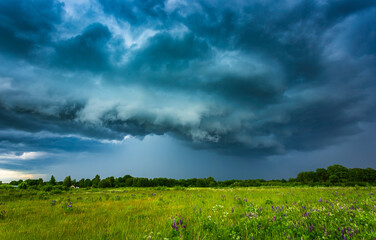 Extreme thunderstorm shelf cloud moving over fields, climate change concept