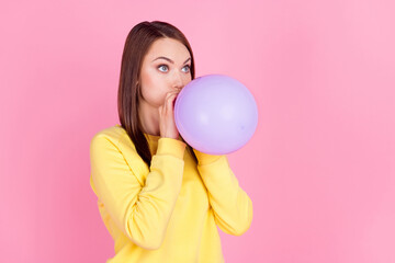 Photo portrait girl inflating purple air balloon preparing to party looking blank space isolated pastel pink color background