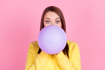 Photo portrait girl inflating purple air balloon preparing to party isolated pastel pink color background