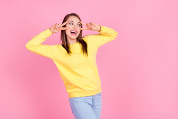 Portrait of attractive cheerful funky optimistic girl showing double v-sign having fun isolated over pastel pink color background