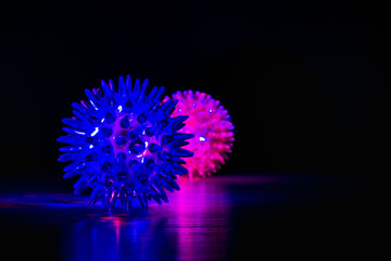 Two glowing balls with spikes in the dark look like coronavirus molecules. Abstract background