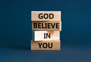God believe in you symbol. Concept words 'God believe in you' on wooden blocks on a beautiful grey background. Businessman hand. Business, religion and God believe in you concept.