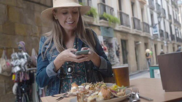 young woman eating tapas in San Sebastian in Spain