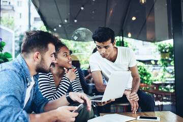 Diverse male and female programmers discussing software developing during collaborative meeting in...