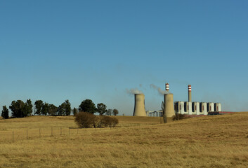 An old fashioned power station burning coal and using cooling towers in order to produce...