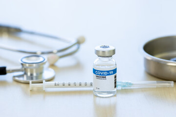 Vaccination concept and medicine: syringe with coronavirus vaccine and disposable vaccination device. Medical device stethoscope to treat flu, coviral-19 virus epidemic.