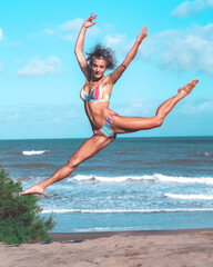 Girl jumping in a bikini on the beach on a sunny day