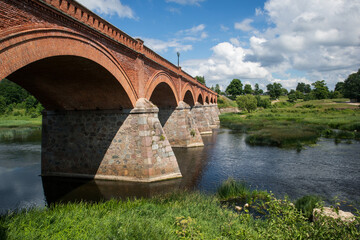 An ancient bridge over the river is built of red bricks