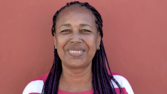 Senior african woman with braids smiling in camera - Elderly african american person laughing