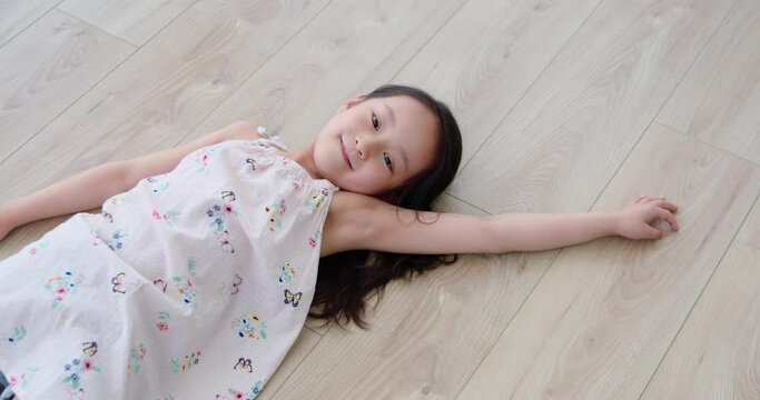 Happy little girl lying on floor,4K