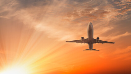 Fototapeta na wymiar Airplane flying over tropical sea at sunset