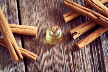 A bottle of essential oil with true Ceylon cinnamon sticks. Aromatherapy or alternative medicine.