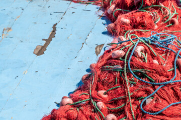 pile of red fishing nets on blue wooden background with copy space