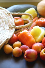 Straw bag and various seasonal fruit and vegetable. Selective focus.