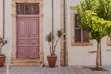 Gordijnen Beautiful building exterior with colored door in Limassol city, Cyprus © garrykillian