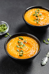 Coconut curry pumpkin soup on dark background.Space for text.