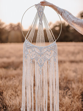 Makramee Arrangement mit Pampasgras auf der Wiese bei Sonnenuntergang