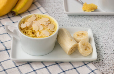  homemade Portioned Banana bread mugcake in small mugs. Easy sweet baking in the microwave idea, With fresh bananas, nuts. Muffin with banana slices cooked in a mug. copy space. High quality photo