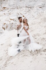 Beautiful wedding couple bride and groom at wedding day outdoors at ocean beach. Happy marriage couple o