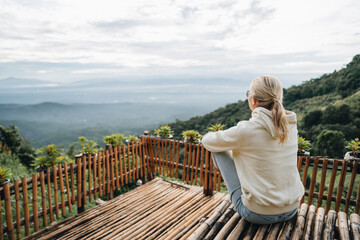 Woman is sitting at viewpoint in strawberry field in Thailand