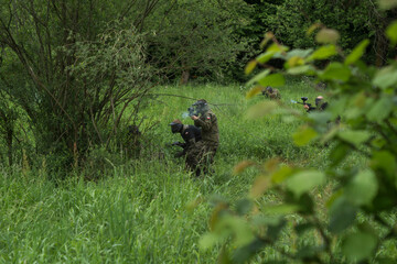 people shooting with paintball pistols