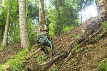 young soldier in military outfit climbing on a steep slope